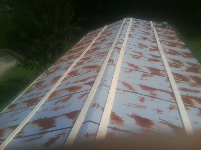 Rusted metal roof panels with new wood purlins before replacement — Storm Damage Roof Repair in Osburn by Roofing Brothers